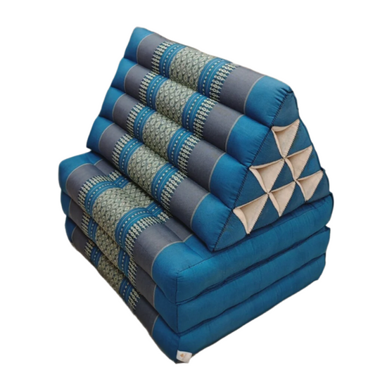 Blue and gray folded cushions on a wooden floor with a wicker chair and decorative basket in the background.