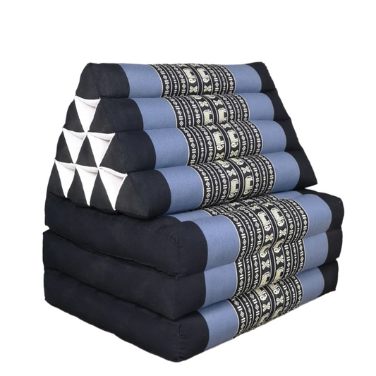 Stack of folded cushions with geometric patterns on a wooden floor.