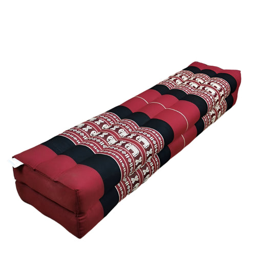 Roll-up seat with red, black, and patterned design on a wooden floor.