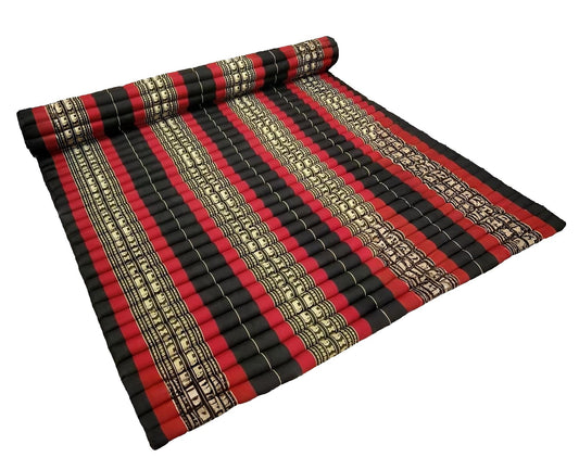 Roll of red, black, and gold striped fabric next to a stack of papers on a white background